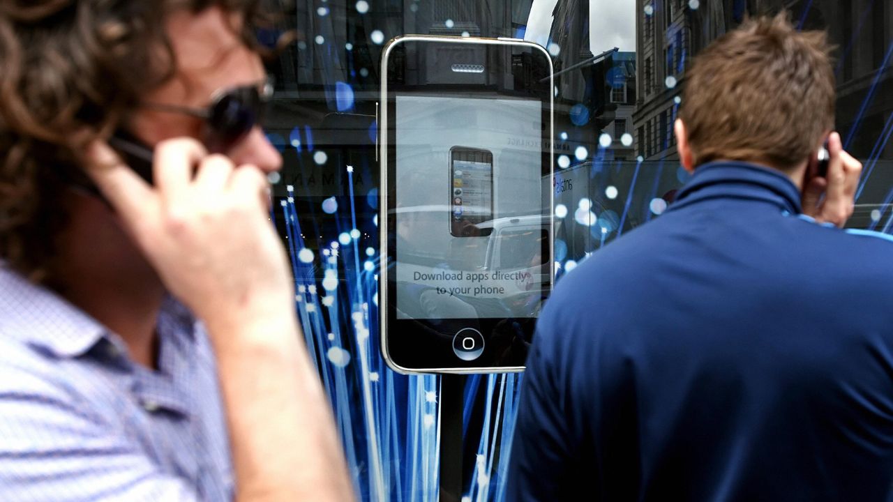 Customers queue outside the Apple Store in London for the launch of the iPhone 3G on July 11, 2008.