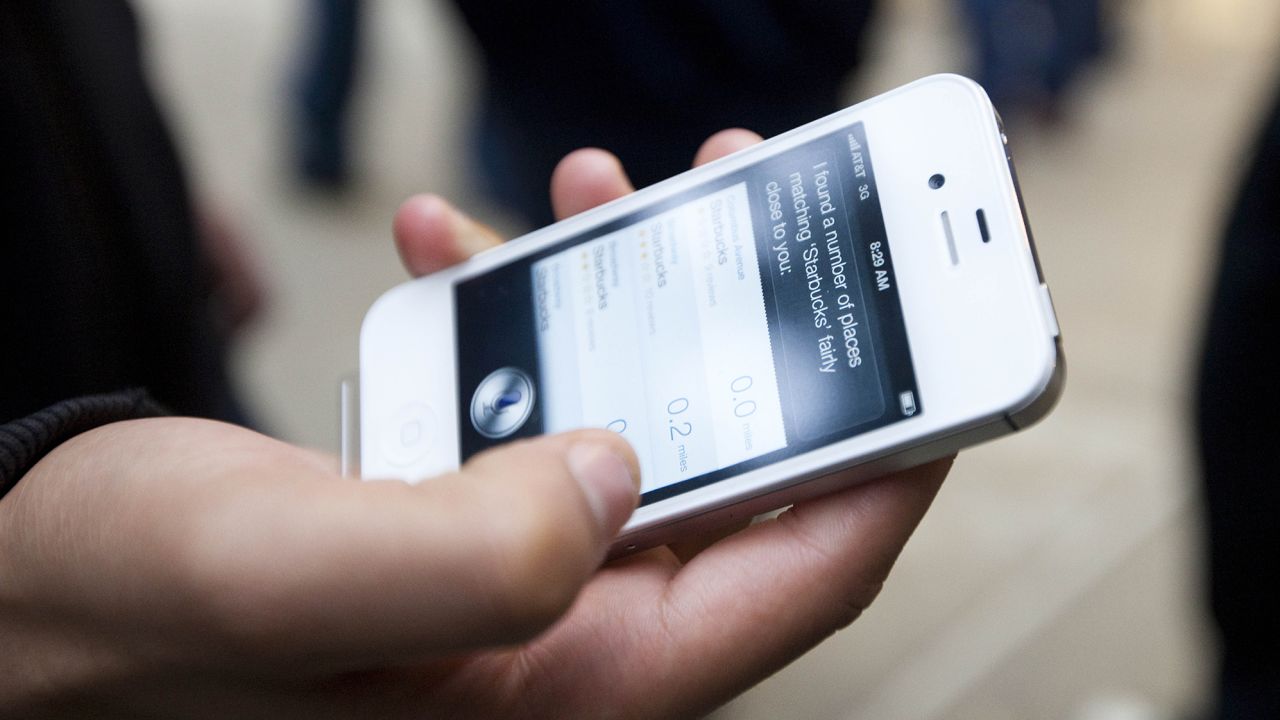 An Apple customer demonstrates the voice assistant program on his newly purchased iPhone 4s outside of an Apple Store in New York City on October 14, 2011.