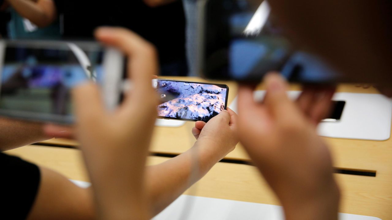 People handle the new Apple iPhone XS and iPhone XS Max during a media tour at an Apple office in Shanghai, China, on September 21, 2018.